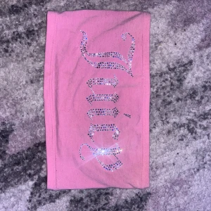 Rosa tubtopp från Juicy Couture - Säljer en superfin rosa tubtopp från Juicy Couture. Den har glittriga stenar som bildar texten 'Juicy' på framsidan. Perfekt för en somrig dag eller en festkväll! 💖