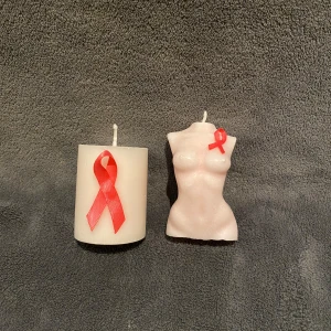 Två ljus med röda band - Oktober är den internationella bröstcancer-månaden. Köp ett cylinder ljus för 40 kr, eller kvinnoljus för 60 kr (båda med doft av blomster) för att visa ditt stöd🩷10% av vinsten går till Bröstcancerförbundet. Kontakta oss för köp🩷