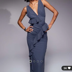 Mörkblå långklänning med volangdetaljer - Säljer denna superfina klänning, helt oanvänd med lappar kvar. 