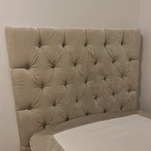 Beige säng & sänggavel med diamanter  SNABB AFFÄR 2500!  - Elegant beige sänggavel med  diamanter  i ett quiltat mönster. Gaveln har en lyxig känsla med sin mjuka textur och dekorativa knappar som ger ett stilrent intryck. Perfekt för att ge sovrummet en sofistikerad touch. Och säng 90x120 i bra skick! Dock är baksidan av gavel lite sönder ( kolla sista bilden) men ändå jätte bra och fräsch! Kontakta vid snabb affär! 