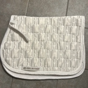 Schabrak från JH collection - Vitt schabrak från JH collection i storlek cob/ ponny, bra skick men lite slitet på insidan. Schabraket är köpt på en second hand affär för 120 kr. Skriv för fler bilder💗Schabraket är 44 cm högt och 60 cm brett
