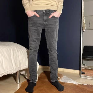 Tiger of Sweden Jeans - Jeans från Tiger of Sweden med slim passform. Jeans är mörkgråa med skön stilren tvätt. Jeansen är i storlek 30W 32L och passar modellen som är 185 och väger 65kg.