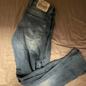 Blå jeans från Replay - Snygga blå jeans från Replay med klassisk femficksdesign och en bekväm passform. De har en diskret tvätt för en modern look och är perfekta för en avslappnad stil. Märkeslappen sitter på baksidan av midjan. Storlek 30 30 skriv vid funderingar 
