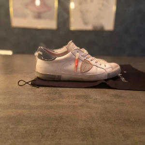 Vita sneakers från Philippe Model - Säljer mina snygga philipe modell med unik design nypris runt 3200 mitt pris 1100 box och påse ingår och några småskador inget som märks hör av er vid intresse! Budning är välkommet