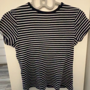 Randig t-shirt från MNG - Säljer en randig t-shirt från MNG i marinblå och vit. Den har korta ärmar. Haft på mig ungefär 5 gånger. Köpte T-shirten för 100 kronor.💙🤍
