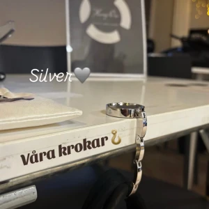 Ihopfällbar krok i silver - Snygg silvrig krok. Perfekt för att hålla väskan säker och nära till hands. Stilren design som passar till alla tillfällen. Håller upp till 5kg