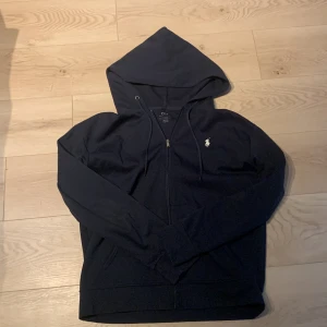Polo Ralph Lauren Hoodie - Fin marinblå hoodie från ralph lauren. Den är knappt använd och i mycket bra skick. Den är Storleken L.