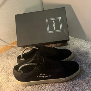 Saint Laurent skor  - !inte autentiska! Säljer ett par svarta Saint Laurent sneakers i storlek 43. Köpte dom för cirka 2700kr av en person, med de visade sig vara fakes, därför säljer jag dem. Använde dem cirka 10 gånger innan jag fick reda på detta, så de är i mycket bra skick. Skriv om ni har några frågor eller om ni vill ha fler bilder. Pris kan diskuteras.