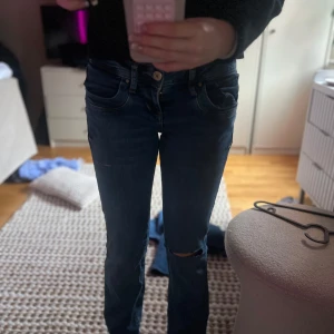 Mörkblå jeans från LTB - Snygga mörkblå jeans från LTB med en tight passform. De har en klassisk femficksdesign och knappar i midjan. Perfekta för en stilren look. Har klippt två hål själv men inte så stora. Är i storlek 25x30 