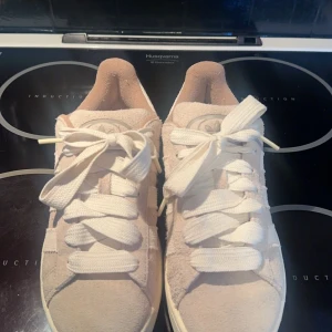 Beige sneakers från Adidas - Säljer ett par snygga beige sneakers från Adidas i mocka med vita snören och sula. Perfekta för en avslappnad stil. De har den klassiska Adidas-loggan på hälen och en bekväm passform. De är köpta från MerchSweden och är endast använda ett fåtal gånger. Färgen kallas för Wonder Beige och skorna är köpta för 2499kr nypris. Kom gärna med pris förslag eller skriv vid frågor😊💕💕 Skorna är i storlek 40 2/3 men passar mig som ofta har 39/40 i skostorlek bra!