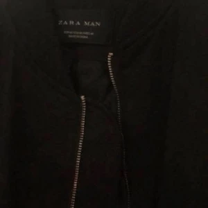 Svart bomberjacka från Zara Man - Snygg svart bomberjacka från Zara Man med dragkedja framtill och en ficka med dragkedja på ärmen. Perfekt för en stilren look. Säljer en bomber jacka lång herr från ZARA. Storleken är M. Skulle säga att den är i gränsen mellan S och M. Knappt använd. Köpte den för 800 kr.  Säljer den för 200 kr.