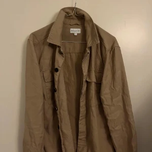 Beige jacka overshirt  från These Glory Days - Säljer en stilren beige jacka overshirt från These Glory Days. Köpt på volt i PK huset Stockholm och knappt använd. inga skador eller defekter det är bara kontakta om du har några frågor kring jackan