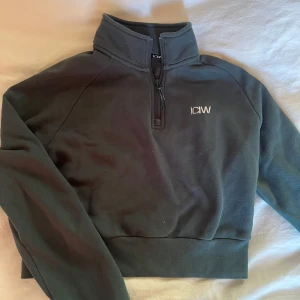 Mörkgrön träningströja - Mörkgrön kroppad träningströja från ICIW som ej säljs längre! Den har hög krage med dragkedja.