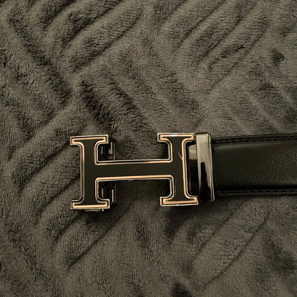 Svart bälte med H-spänne