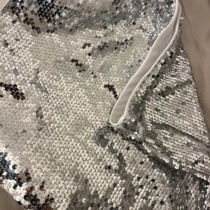 Silver kjol - Snygg och glittrig silverkjol täckt med paljetter. Perfekt för att sticka ut på festen. Klänningen har en elegant design med en slät insida för komfort . Har ej använts då den kom försent när jag ville ha den på nyår