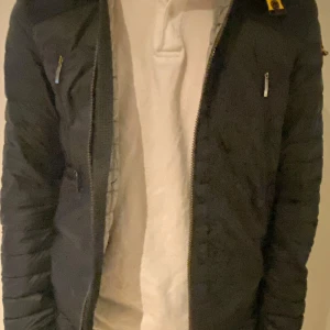 Parajumpers featherweight täckjacka - Säljer en snygg mörkblå dunjacka från Parajumpers. Jackan har en dragkedja framtill och är quiltad för extra värme. Den är lätt och bekväm med en cool patch på ärmen. Perfekt för kyliga dagar!