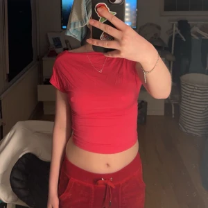 Rosa kortärmad topp med öppen rygg - Säljer en snygg röd kortärmad topp med öppen rygg. Toppen är tight och croppad, perfekt för en trendig look. Passar bra till både jeans och kjol.