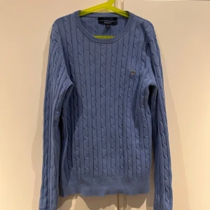 Blå kabelstickad tröja från GANT - Säljer en snygg blå kabelstickad tröja från GANT i stretchig bomull. 