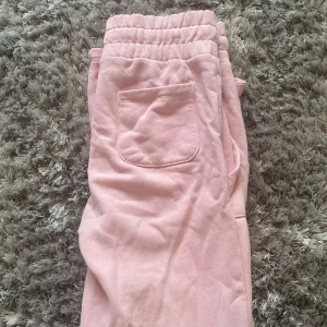 Rosa mjukisbyxor med snörning - Säljer ett par bekväma rosa mjukisbyxor med elastisk midja och snörning. Byxorna har praktiska fickor på sidorna och är perfekta för en avslappnad stil.