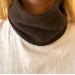 Mörkbrun kashmir buff - Snygg och enkel mörkbrun kashmir buff i mjukt material. I nyskick endast testad och säljes då den inte kommer till användning.