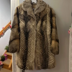 Brun pälsjacka - Säljer en elegant brun pälsjacka med långa ärmar och en klassisk krage. Jackan har en mjuk och lyxig känsla, perfekt för kyliga dagar. Den stängs med diskreta hakar framtill. Passar storlek M/L