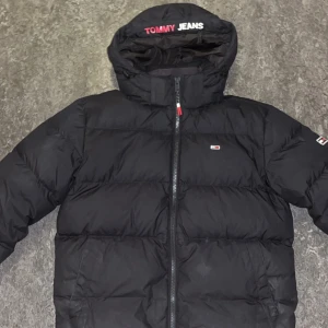 Tommy jacka - Säljer en svart dunjacka från Tommy Jeans, perfekt för den kalla vintern som kommer. Jackan är nästintill oanvänd, säljer för att jag har en annan jacka. Vid minsta frågor o funderingar, kontakta mig!