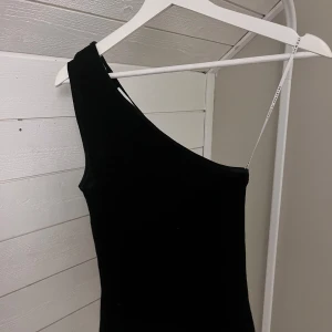 Svart/mörkblå oneshoulder topp - Svart/mörkblå oneshoulder topp med lite glitter. Perfekt för nyår! Kommer inte till användning, använd endast en gång! Pris går att diskutera.