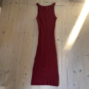 Vinröd ribbad klänning från Forever 21 - Snygg vinröd ribbad klänning från Forever 21. Den är ärmlös och har en figurnära passform som sträcker sig ner till anklarna. Perfekt nu till jul.