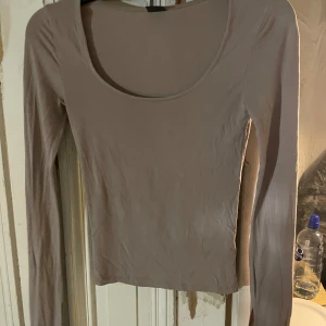 Beige långärmad topp från Gina Tricot - Säljer en stilren beige långärmad topp från Gina Tricot i storlek XS. Toppen har en rund halsringning och är perfekt för lager-på-lager eller som den är. Passar till många olika outfits!