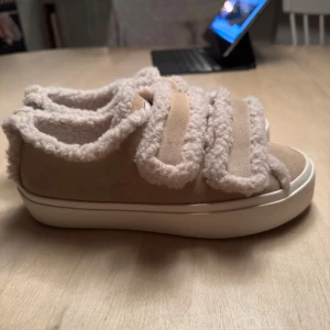 Inuikii skor  - Säljer ett par beige sneakers med fuskpälsdetaljer och kardborreband. Säljer då jag har likadana i annan färg! Som nya bara sulan som är smutsig (ljuset som gör att de ser smutisgare ut) 🩷pris går att diskutera