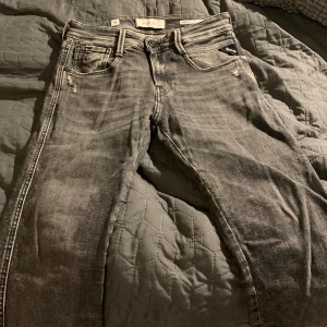 Replay jeans i grått/svart - Snygga Replay jeans i grått med en klassisk femficksdesign. De har en straight passform och är tillverkade av ekologisk bomull. Perfekta för en avslappnad stil. Modellen är Anbass 