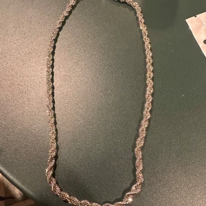 Silverfärgat halsband 5mm - Elegant silverfärgat halsband med en vriden design som ger en glittrig effekt. Perfekt för att lägga till en touch av glamour till din outfit.