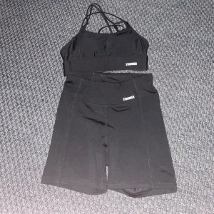 Svart träningsset från STRONGER - Snyggt svart träningsset från STRONGER med en sport-bh och matchande shorts. Sport-bh:n har smala axelband och en stilren design. Shortsen är höga i midjan och kan lätt vikas upp om man vill ha kortare shorts. Båda är i storlek S, använt några gånger men kommer inte till användning längre. Settet är i bra skick utan skador. Kontakta för mer bilder eller  information💓