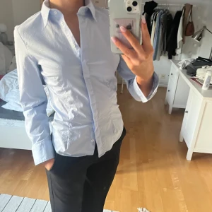 Ljusblå skjorta - Säljer denna snygga figursydda skjortan. Använd ett fåtal gånger, inga defekter 