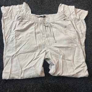 Beige linnebyxor med resårmidja - Säljer ett par bekväma beige linnebyxor med resårmidja och snörning. Aldrig använt 