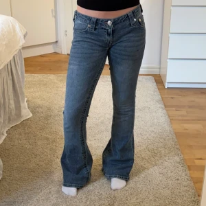 Blå bootcut jeans från True Religion - Snygga lågmidjade jeans från True Religion i modellen Nelly Ultra Low Rise Joey Flare. Midjemått tvärs över: 39 cm, innerbenslängd: 81 cm. Endast använda en gång så de är i nyskick! Nypris 1399 kr 💗💗