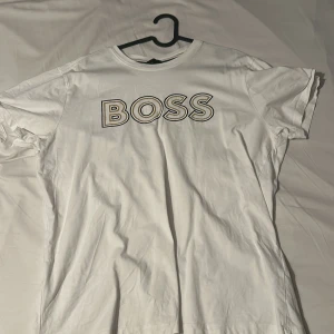 Vit t-shirt från Boss - Snygg vit t-shirt från Boss med stort tryck på bröstet. Perfekt för en avslappnad stil.
