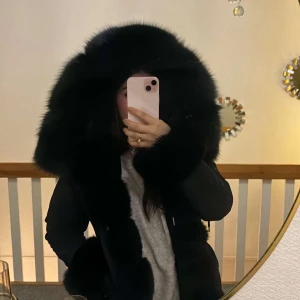 Svart Fatimajacka med päls - Säljer en  svart fatimajacka med stor päls runt huvet och matchande päls vid ärmsluten. Jackan har en elegant design som passar perfekt för kyliga dagar.