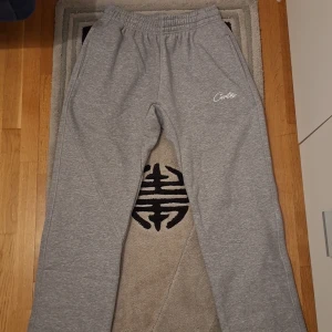 Helt Nya Corteiz HMP Straight Jogging Pants  - Säljer ett par helt nya och oanvända Corteiz HMP Straight Jogging Pants i storlek Medium (M), i en snygg grå färg. Byxorna är både stilrena och otroligt bekväma, men säljs eftersom de tyvärr är för små för mig. 