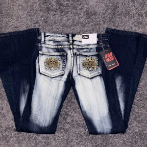 Mörkblå jeans med broderi från Any Way - Snygga mörkblå lågmidjade jeans med unikt broderi i guld på bakfickorna. Jeansen har en cool wash på både bak och framsidan. Byxorna är utsydda till bootcut/flare därmed en extrasöm och är gjorda i slitstarkt denim. Innerbenslängd 84 cm och midjemått tvärs över är 37 cm ❤️PRIS ÄR DISKUTERBART!!! ❤️❤️