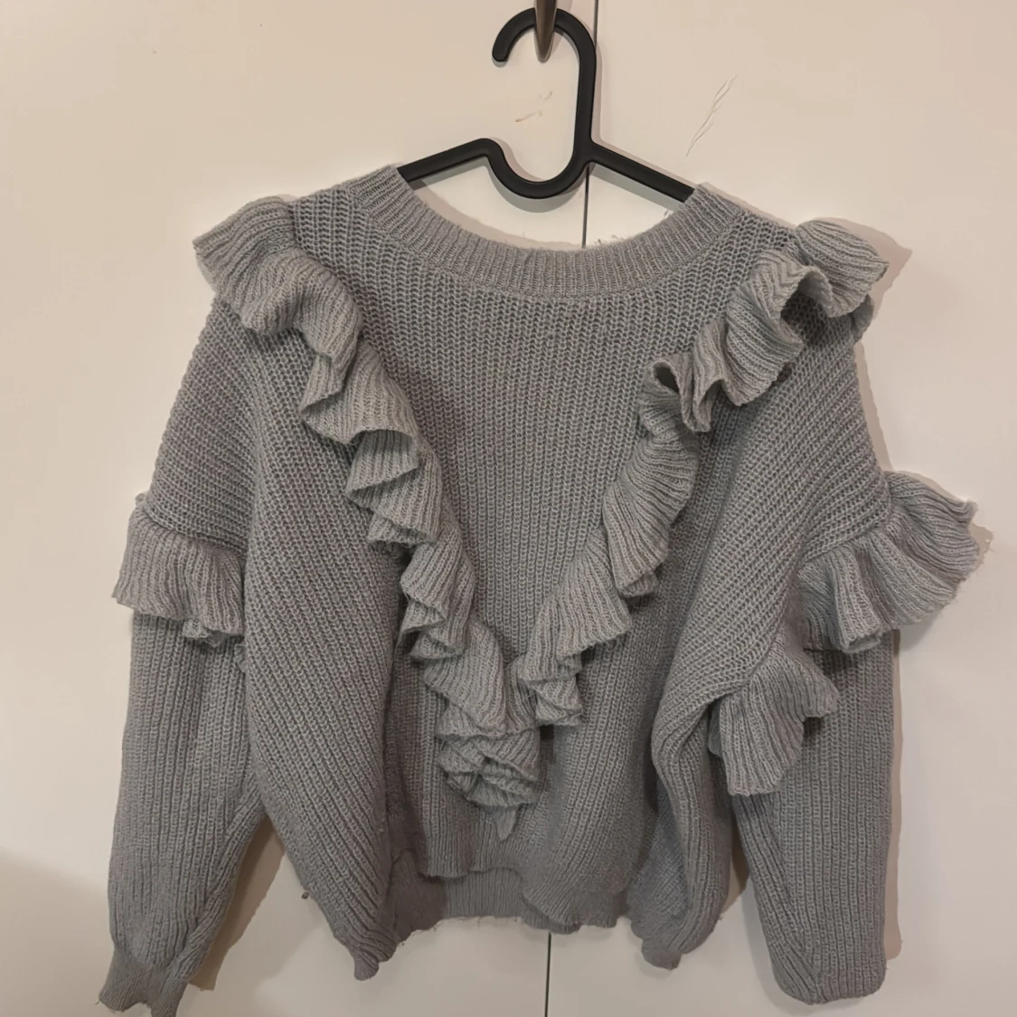 Grå stickad tröja med volanger