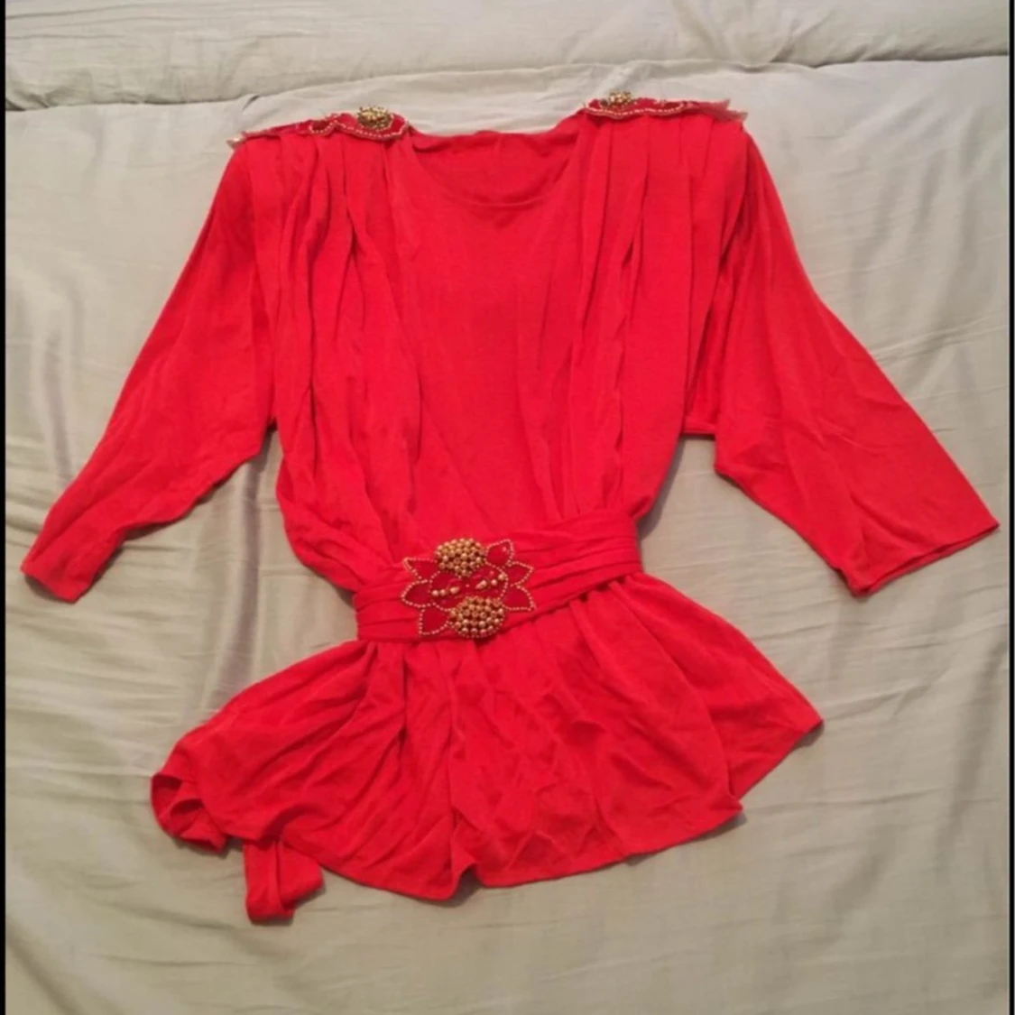 Röd blus med dekorativa detaljer