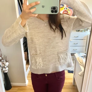 Beige stickad tröja med fransdetaljer -  mysig beige stickad tröja med fransdetaljer på fickorna från odd Molly. gar!