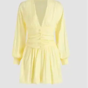 Gul klänning med v-ringning - Charmig gul klänning med v-ringning och långa ärmar. Den har en smickrande passform med rynkade detaljer i midjan och en kort kjol som ger en lekfull look. Tyvärr passade inte klänningen mig där av inga fler bilder kom provay för fler bilder. 