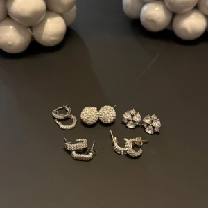 Set med glittriga örhängen✨ - Säljer ett set med fem par glittriga örhängen. Inkluderar tre par små hoops och två par studs, alla i silverfärg med gnistrande stenar😇säljer för att jag byter till guldsmycken💖🩷