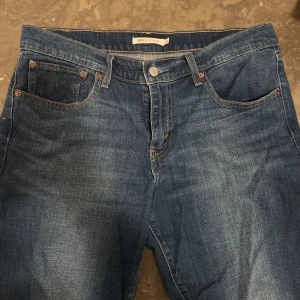 Levi's 415 Relaxed Bootcut Jeans - Snygga Levi's 415 jeans i en klassisk blå denim. Dessa jeans har en avslappnad bootcut-stil och är perfekta för en bekväm look. De har fem fickor och en knappgylf med dragkedja. Perfekta för dig som gillar en tidlös stil.