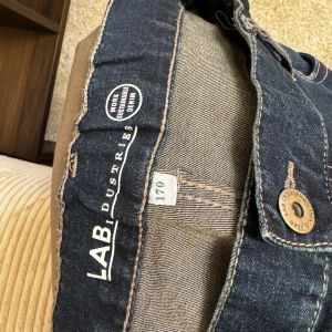 Mörkblå jeans KappAhl strl 170 - Ett par mörkblå jeans från LAB Industries. Byxorna har en klassisk design med fickor fram och bak. Kön: pojke Skick: bra skick Storlek: 170  Din stil: spara inlägget så du inte missar denna kappa Inte din stil: Kolla min profil. Du kommer hitta något för alla kön och åldrar.