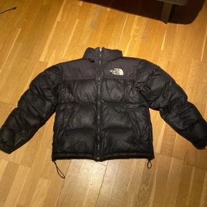 The north face puffer jacket Svart - Säljer en svart dunjacka från The North Face. Varm jacka, perfekt för vintern. Några små skador på ryggen som inte syns eller märks av, syns på bild 3. En lagning på armen som syns på bild 4.            Storlek S men passar de flesta längder, nypris 3899kr. 