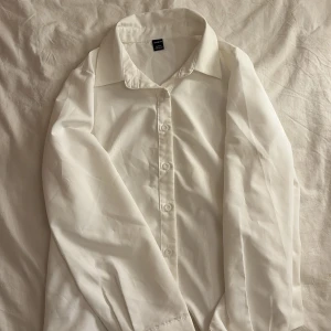Vit skjorta  - Klassisk vit skjorta. Skjortan har långa ärmar och en normal passform. Tillverkad i ett mjukt och bekvämt material. använd en gång 
