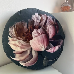 Prydnads kudde - En rund prynadskudde med en rosa blomma på, snygg att ha i soffa eller sängen. För att få de extra. 